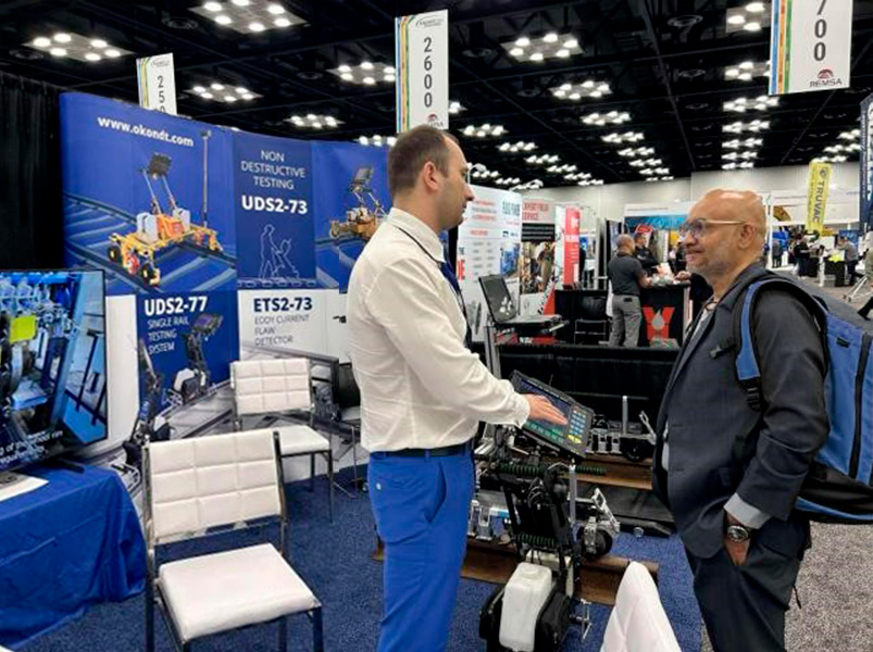 At Railway Interchange 2025, an OKONDT GROUP specialist consults with an exhibition visitor about the UDS2-77 rail flaw detector